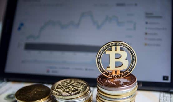 Bitcoin coins in front of laptop