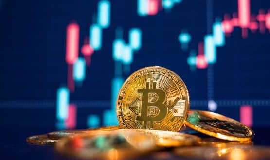 Bitcoin coin in front of trading chart