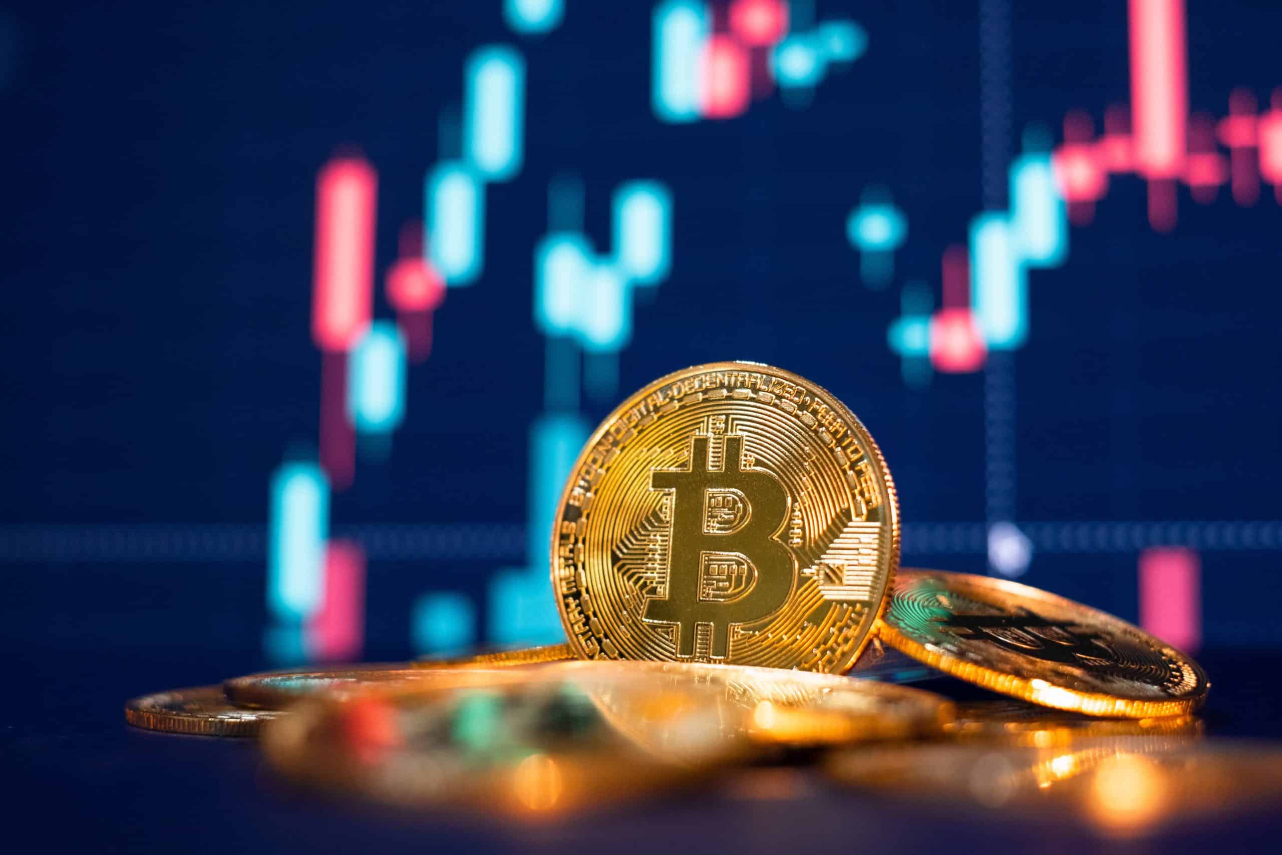 Bitcoin coin in front of trading chart