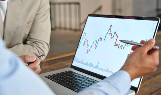 Man pointing at laptop with price chart