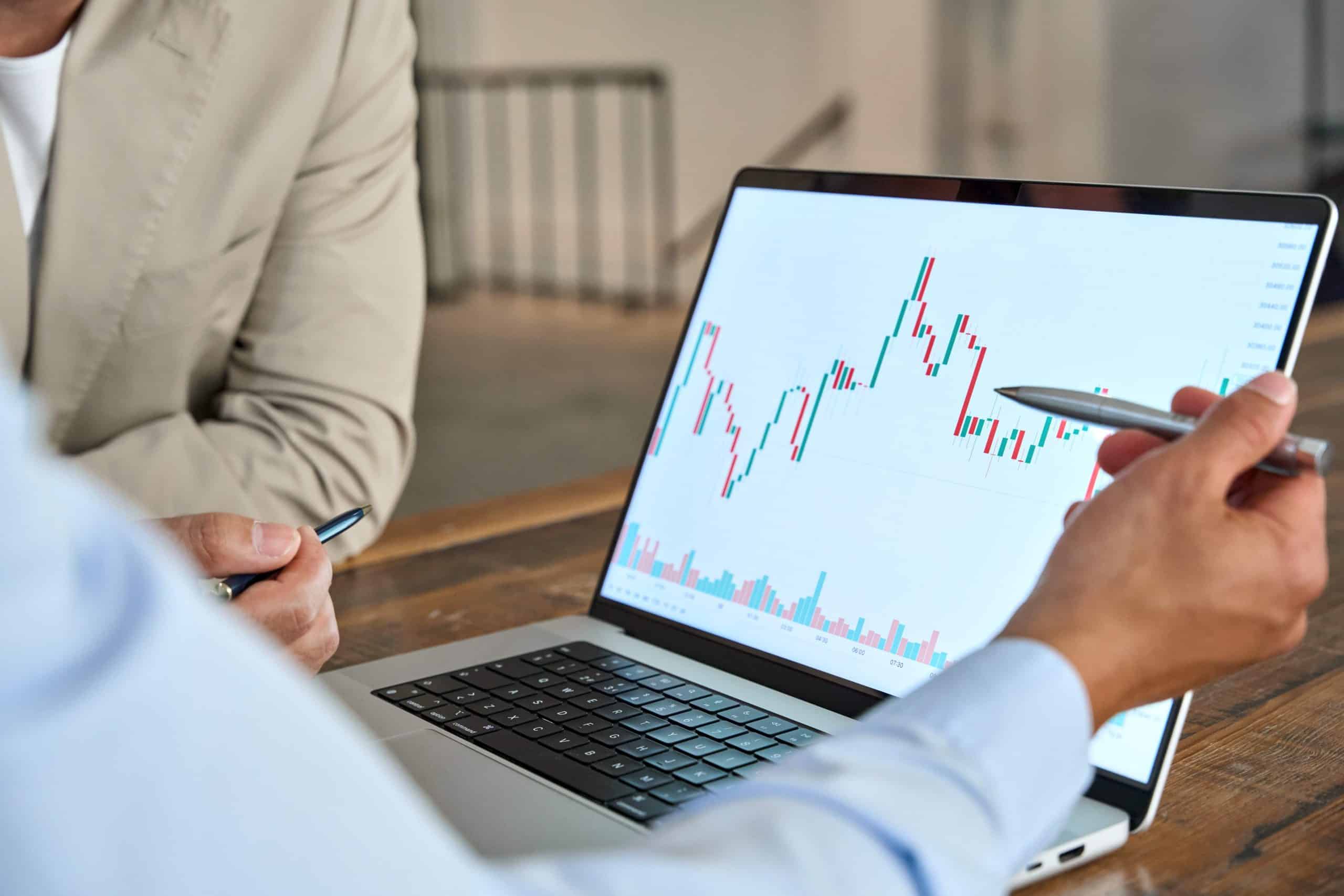 Man pointing at laptop with price chart