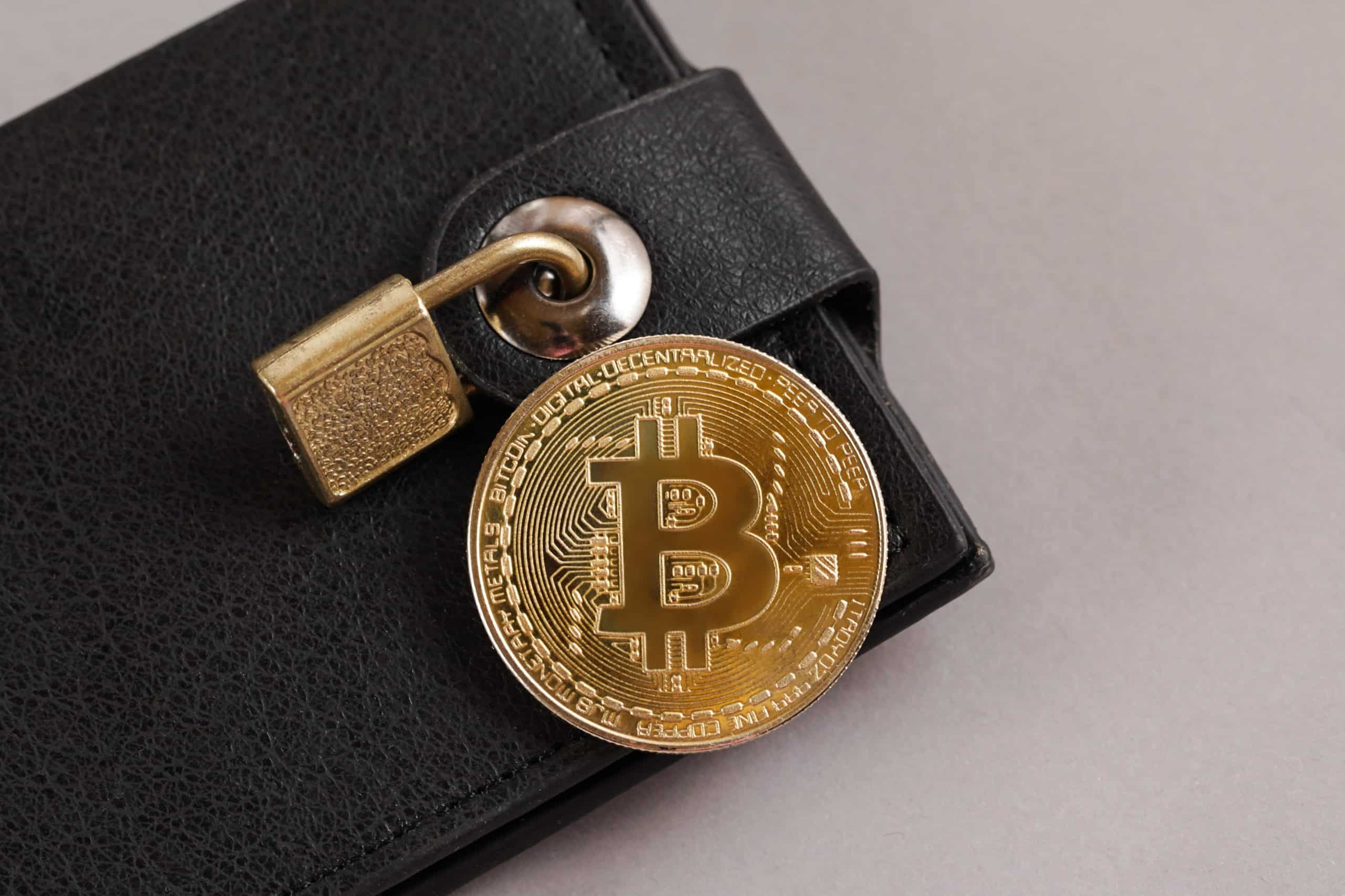 Bitcoin coin on wallet with a lock on it