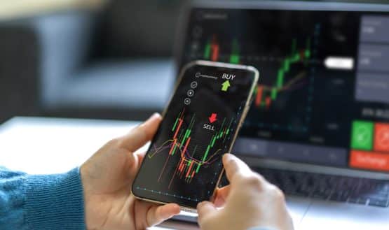 trading chart on phone and laptop