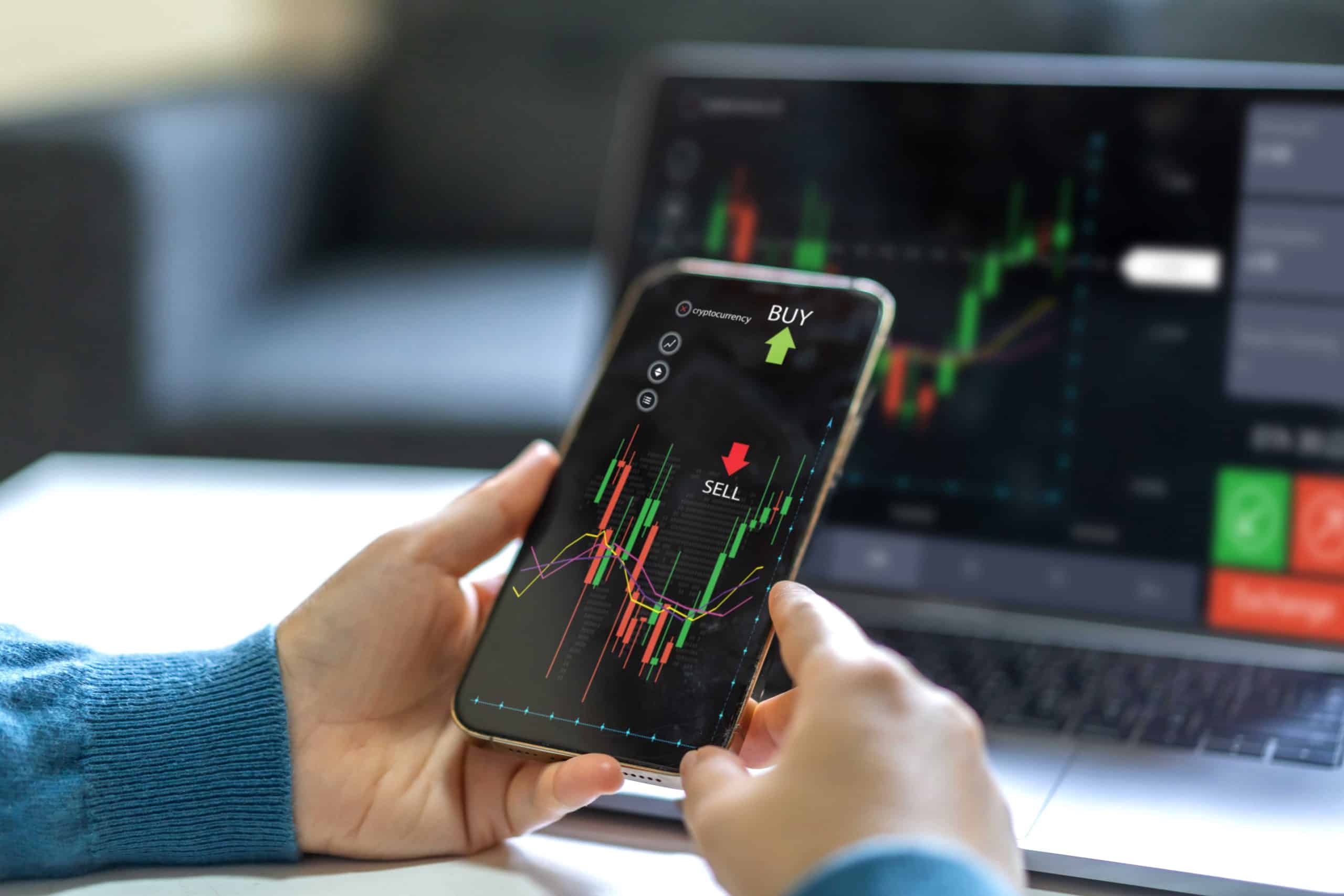 trading chart on phone and laptop